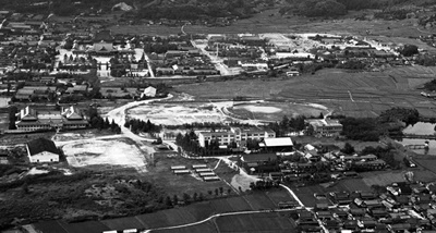 1959年当時の航空写真。左側の中央にあるのが現天理高校校舎。そのすぐ上にある建物群が鑵子山校舎と呼ばれ、この中に短大があった。中央には現1号棟がある。（集成部史料掛所蔵）