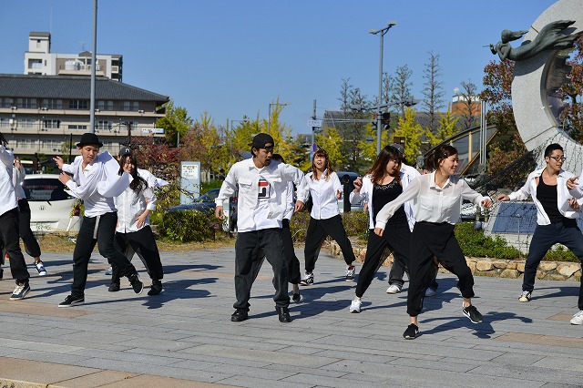 駅前広場の舞台で踊るダンスチーム